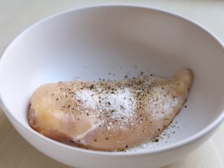 2、芝麻菜西柚鸡肉沙拉,鸡胸肉比较厚可以对半剖薄些,这样比较能入味,这里不厚就没剖。用刀背将鸡胸肉稍拍松些,撒上盐、黑胡椒。