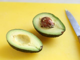 4、芝麻菜西柚鸡肉沙拉,选熟了的牛油果,纵向对半切至果核处,双手拧开,去皮。