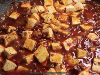 5、麻辣鲜香的麻婆豆腐,辣椒粉、青花椒粉翻炒均匀，下料酒炒干，适量生抽，下豆腐，用铲背推动均匀。下一碗高汤或清水，咕噜5分钟