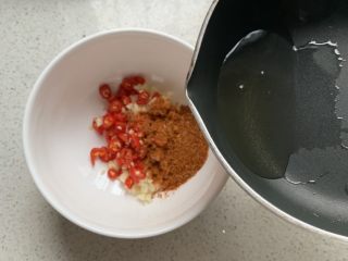 6、凉拌茄子,倒入放了小米椒、蒜泥、辣椒粉的小碗中，激发一下香味