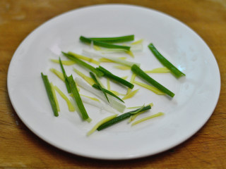 4、清蒸白鲳鱼,在盘子底部铺上一些姜丝和葱段