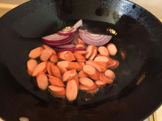 5、卷心菜香肠炒面,再放入切好的洋葱继续煸炒。大概炒一分钟。