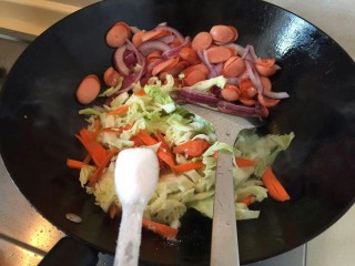 7、卷心菜香肠炒面,放一勺盐调味，煸炒均匀。