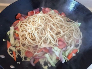 9、卷心菜香肠炒面,把把煮好的面条放入锅中和蔬菜一起煸炒。