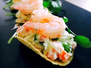 14、鲜虾土豆泥,取一片薯片,勺入适量的土豆泥,摆上一个鲜虾仁,用芝麻叶装饰。