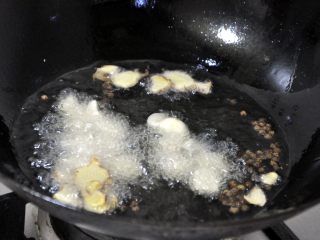 6、香辣干锅兔, 重新换一锅油，烧开后，倒入花椒、姜、蒜。