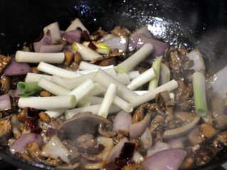 13、香辣干锅兔,倒入大葱段，继续翻炒。