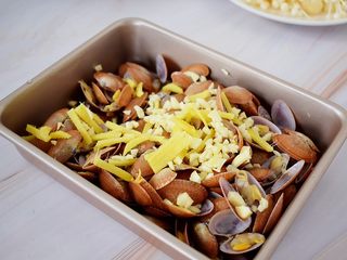 8、花甲粉,先把花甲放入烤盘中，放入蒜末和姜丝