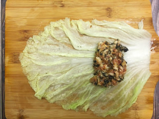 4、金玉白菜卷,将白菜叶铺平，放上肉馅，两边的菜叶往肉馅包上，再从下往上卷起