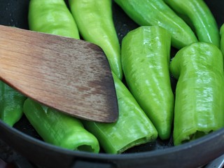 6、虎皮尖椒,煎制的过程中用锅铲按压尖椒,使尖椒里的水汽排出来,这个煎制的过程可以让尖椒的辣味跑光,吃起来就不会觉得辣嘴了