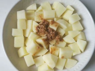 12、香酥排骨蒸土豆,把刚才排骨料理碗里的剩余酱料和蒜蓉倒进土豆里