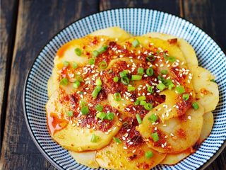 12、凉拌土豆片,盛进盘子里,撒上葱花,白芝麻即可。