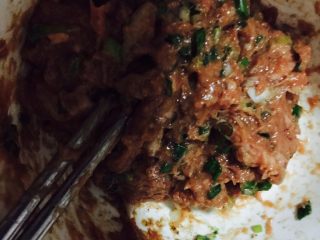 15、鱼香茄饼,将肉馅从冰箱里取出放入葱花稍微搅拌一下即可