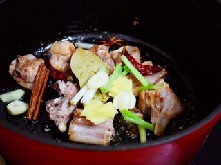 5、排骨炖土豆,放入葱姜蒜和八角、桂皮、香叶、干红辣椒翻炒出香味