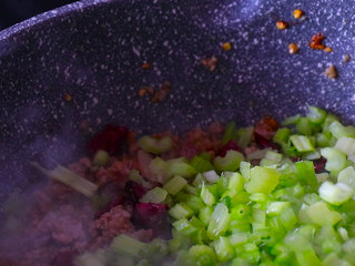 10、下饭菜芹菜炒肉末,肉末翻炒均匀后加入芹菜末。