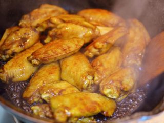 7、可乐鸡翅,放入生抽、老抽、料酒、蚝油和盐，翻炒均匀。