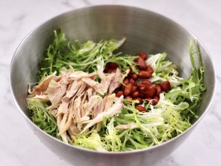 11、鸡丝拌苦苣,把撕好的苦苣放入盆中,上面放入鸡丝和花生米。