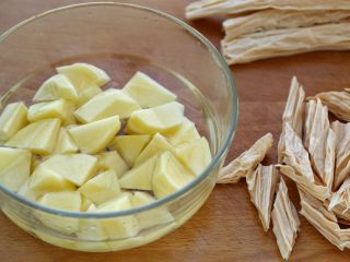 2、鸡翅腐竹烧土豆,腐竹提前泡发，挤干水分切成斜段。土豆去皮后切滚刀块，冲掉表面的淀粉浸泡在清水中防止氧化变色