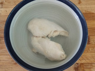 5、鸡丝凉面,这个时候的鸡胸肉也煮好了，我们把鸡胸肉捞出来马上放入冰水中，热胀冷缩，能有效的锁住鸡胸里面的水分。