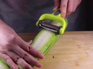 4、丝瓜换种新鲜做法,比炒蛋还要好吃百倍,将去皮后的丝瓜洗净后,用刮皮刀刮成薄片备用。