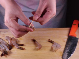 6、丝瓜换种新鲜做法,比炒蛋还要好吃百倍,虾去壳洗净后,用牙签从虾背(第三个关节处)挑出虾线。接着用刀子给虾开背。