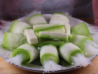 11、丝瓜换种新鲜做法,比炒蛋还要好吃百倍,将做好的丝瓜卷绕着盘子的四周摆放,将剩下的粉丝跟丝瓜条放入盘子中央。