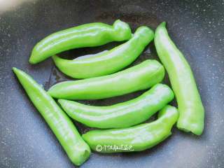 2、虎皮青椒,锅里放油，青椒下锅煸炒，用锅铲不断挤压