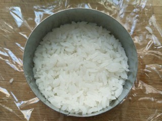 4、米饭猪肉堡,用勺子挖一勺米放入模具中压结实压平整。