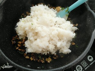 15、雪菜香菇团子,把蒸好的糯米饭放一部分到锅里