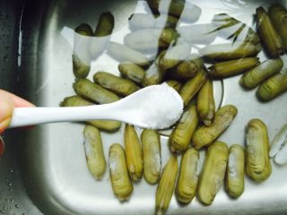 2、葱油蛏子,将蛏子表面的泥土冲洗干净再加入1小勺盐浸泡两个小时，让蛏子里的泥沙吐干净