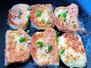 8、香煎馒头片,两面都煎至金黄色我喜欢吃脆一点的就多煎了一会再撒上葱花和黑芝麻即可出锅享用