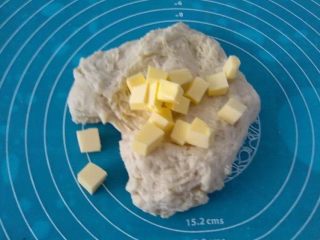 3、梅花双色土司,把切成小块的黄油加入面团.