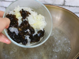3、凉拌双耳,把木耳银耳放进开水里，煮5分钟，捞出来，过凉水，攥干水份