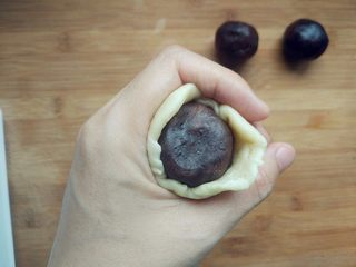 15、豆沙蛋黄酥,用右手拇指按住馅，左手虎口形成的圈不断旋转着挤压皮，逐渐缩小封口