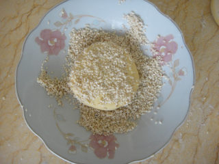 12、南瓜炼奶紫薯饼,每一个饼表面沾上适量清水沾上芝麻