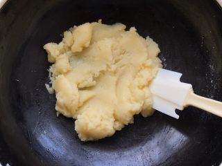 4、#不一样的泡芙#蓝莓果酱樱花泡芙,用硅胶产翻拌至水油面完全融合,关火;把锅端过来冷却至60度左右