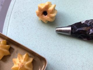 11、#不一样的泡芙#蓝莓果酱樱花泡芙,从泡芙底部打入蓝莓果酱