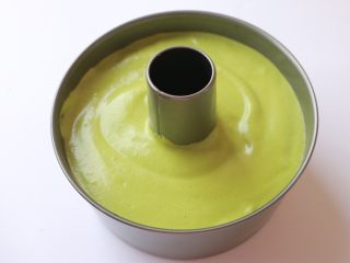 19、低糖少油菠菜戚风,做好的蛋糕糊倒入模具中，装七分满即可，并将模具中的面糊稍稍抹平，然后提起模具在桌上轻磕几下，震出气泡