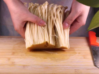 3、往青椒里塞入半斤金针菇,这味道绝了!,用手将金针菇掰开后洗净装盘备用。