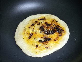 8、生椒鸭肉披萨,观察手抓饼表面无“白心”后，抹上一层香辣豆豉酱；