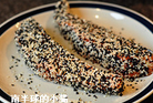 6、芝麻脆皮三文鱼,放入装有芝麻的碟子里，让它每面都沾满芝麻（带皮那面除外）