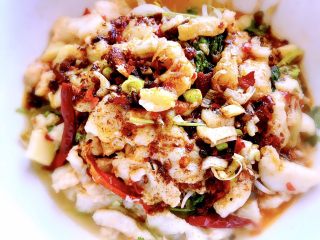 22、家常水煮鱼,把鱼肉捞在煮好的菜碗里，切葱花撒在上面，把之前盛出的麻辣油再加热，趁热浇在鱼片上。