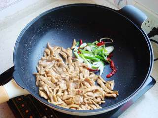 6、青椒炒肉片,倒入葱和辣椒。