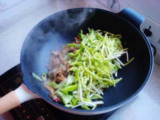 9、青椒炒肉片,最后倒入青椒和蒜黄。