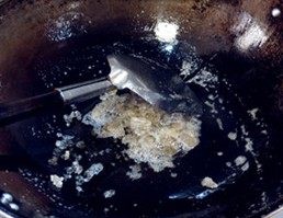 9、虎皮鹌鹑蛋红烧肉,接下来是炒糖色,冰糖砸碎放进油锅进行翻炒,要用小火,用锅铲一直不停的搅动