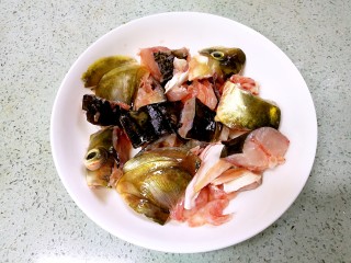 4、蒜香豆豉蒸鱼头,把鱼头斩切成小块。