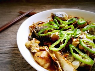 17、蒜香豆豉蒸鱼头,把青椒圈摆放在鱼头上,再浇上热油。