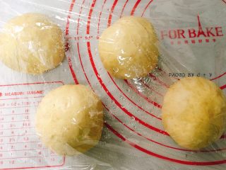 8、健康早餐首选的小麦胚芽餐包,取出面团排气，分成四等份揉成团，盖上保鲜膜松弛一刻钟。