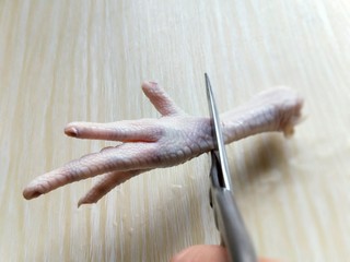 5、健康零食～香糟凤爪,把鸡爪剪开，首先将鸡爪的根部剪下来，如图。