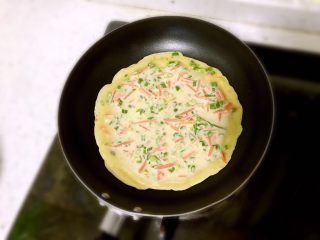 10、三色鸡蛋饼，吃出健康吃出爱,放入一勺面糊，摇匀，其间晃晃锅，表面凝固后。